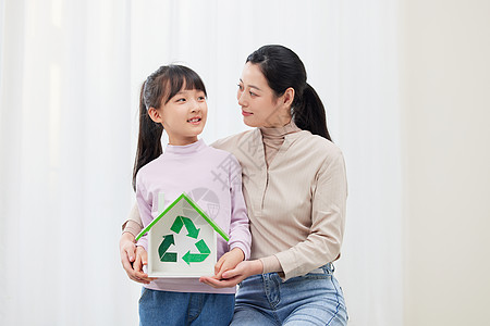 手捧地球妈妈和女儿手捧环保可回收标志背景