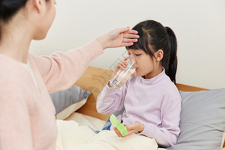 孩子生病妈妈照顾生病的女儿吃药背景