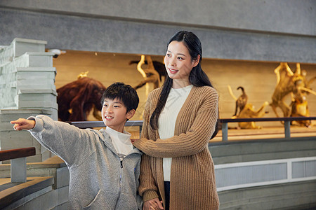 儿童骨骼发育年轻妈妈带儿子参观自然博物馆背景