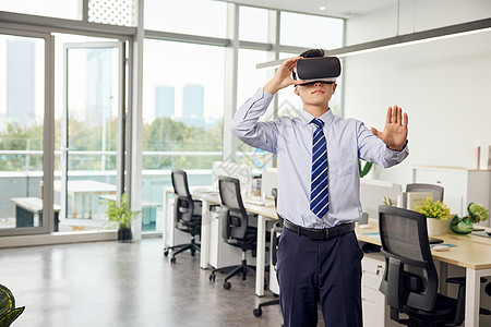 vr看房办公室里带着vr眼镜的男性虚拟操作背景