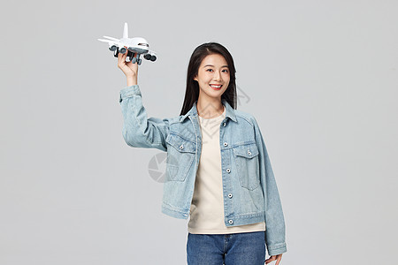 手拿飞机模型的青年女性图片