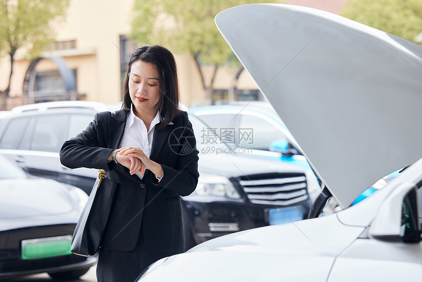 驾驶新能源汽车的商务女性白领查看手表图片