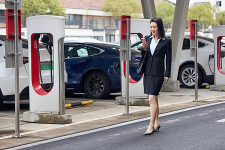 寻找新能源汽车充电桩的商务女性图片