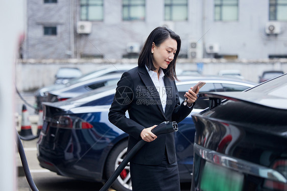 女性使用手机操作智能充电桩图片