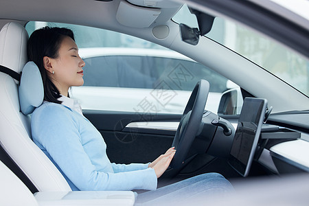 在汽车驾驶座上休息的女性图片