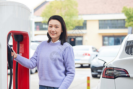 手扶新能源充电桩的女性图片