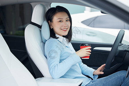 坐在车里的女性手拿咖啡杯高清图片