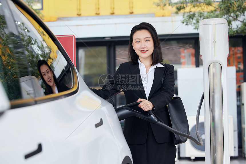 白领女性给新能源汽车充电形象图片