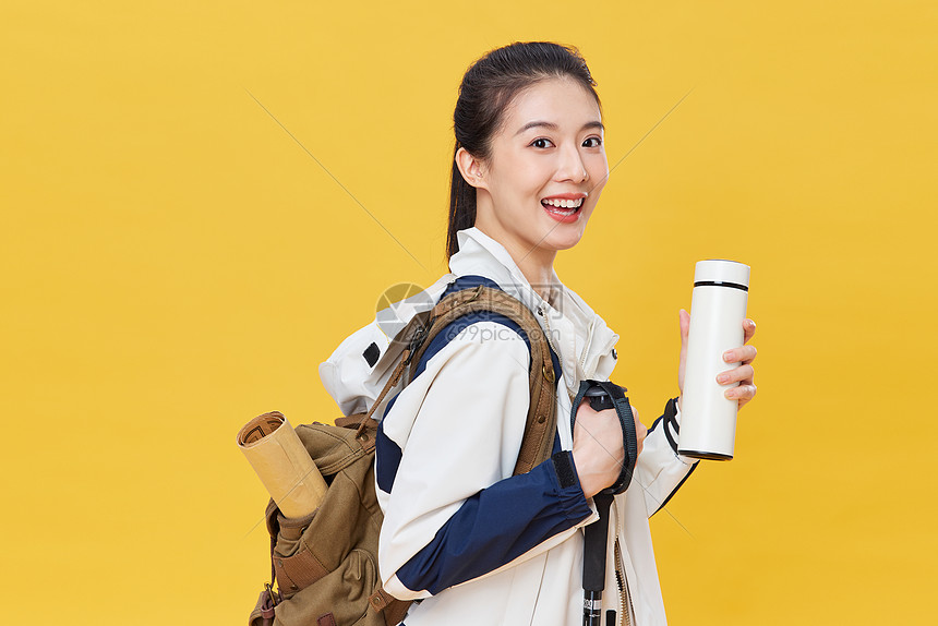 登山徒步手拿保温杯的青年女子图片