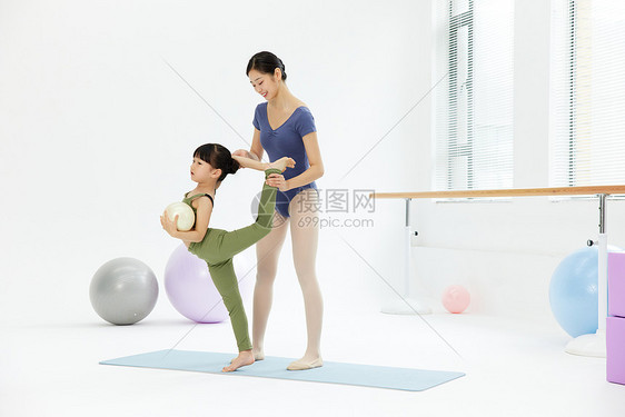 年轻女老师教小女孩体操图片