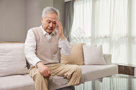 坐在客厅头疼眼花的爷爷背景图片