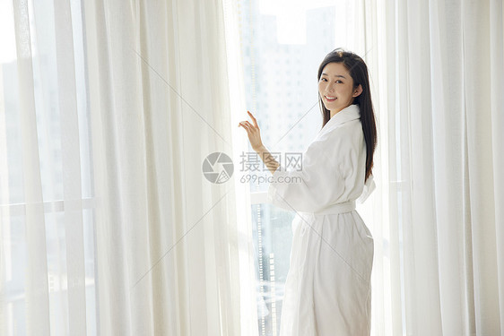 年轻美女酒店窗前回眸图片