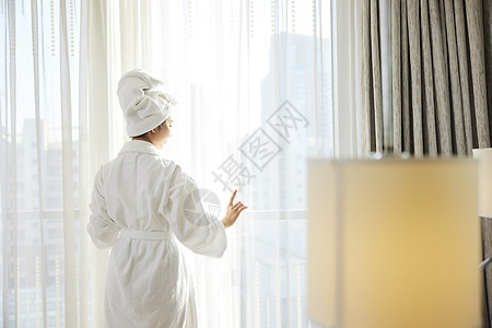 年轻美女酒店窗前享受风景图片
