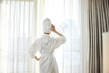 年轻美女酒店窗前享受旅行度假时光图片