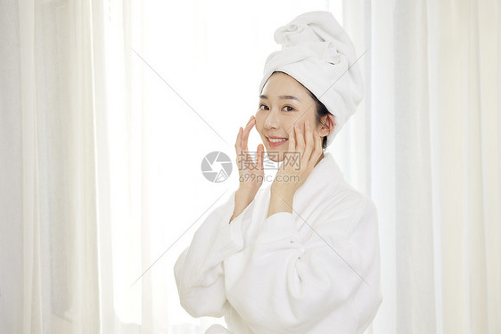 身穿浴袍的年轻美女美容护肤图片