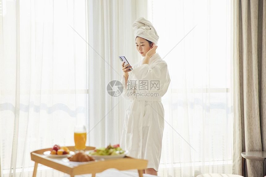 年轻美女酒店下午茶休息玩手机图片
