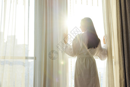 美女酒店早晨起床拉开窗帘背影图片