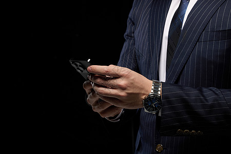 黑色背景使用手机的商务男性图片