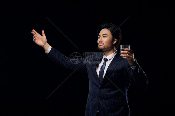 高举酒杯的正装商务男性图片