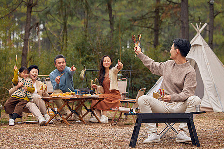 家人烧烤一家五口户外露营烧烤美食背景