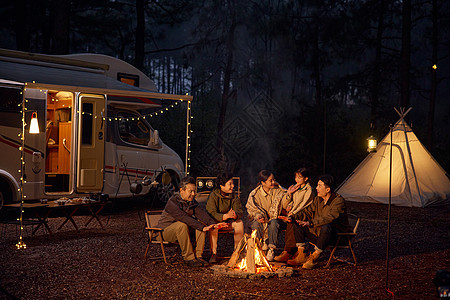 一家人夜晚森林露营烤火图片