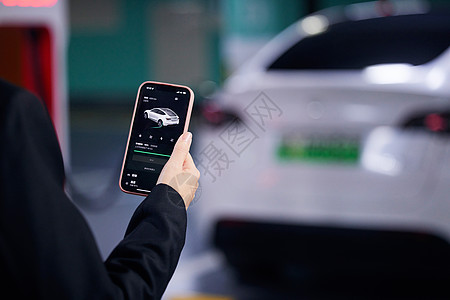 绿色环保科技使用手机操控新能源汽车特写背景