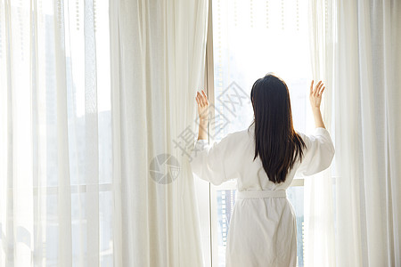 美女酒店早晨起床拉开窗帘背影图片