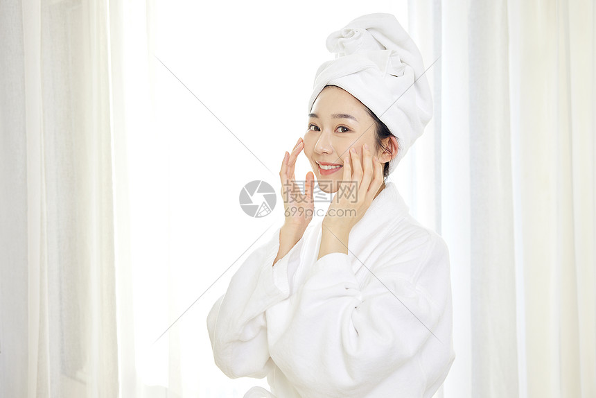 身穿浴袍的年轻美女护肤图片