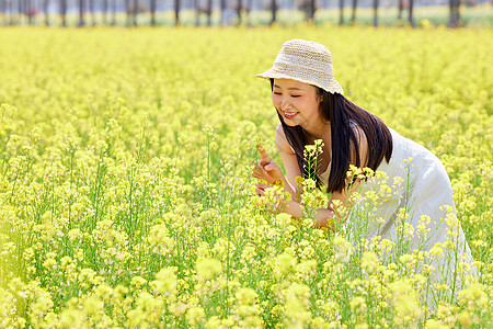 站在油菜花田里的美女图片