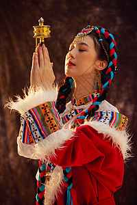 手拿放大镜手拿经轮祈祷的藏族女性背景