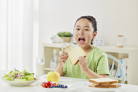 儿童大口吃早餐面包图片