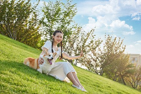 少女带爱宠户外游玩拍照图片