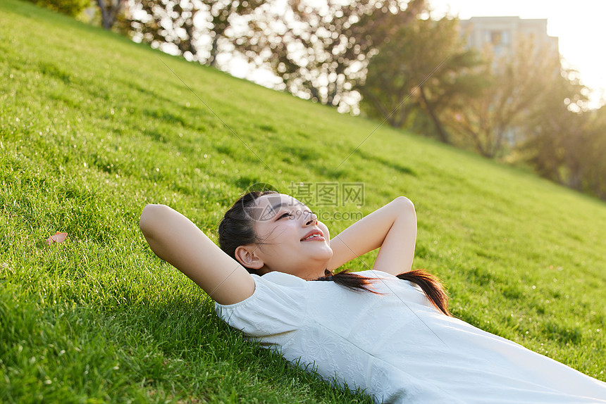躺在草地上晒太阳的青年女子图片