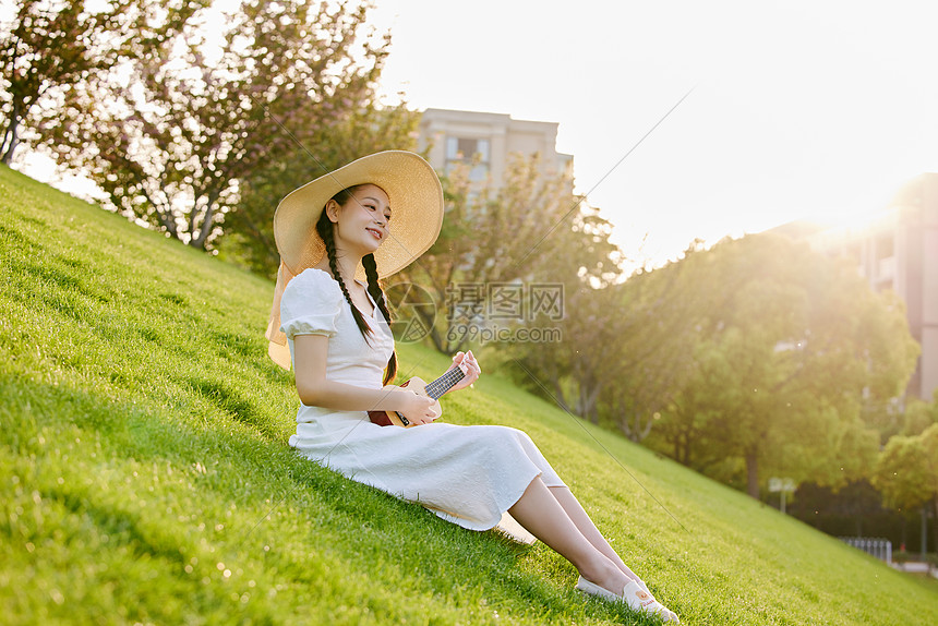 草坪上的文艺女性弹尤克里里图片