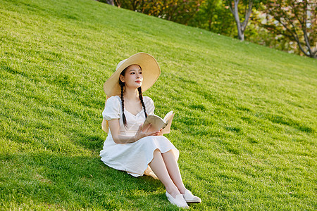 青年女性草坪上看书图片