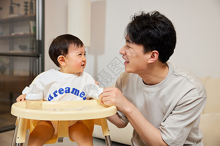 小婴儿与父亲对视微笑图片