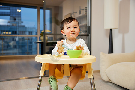 婴儿椅坐在宝宝椅上吃辅食的婴幼儿背景