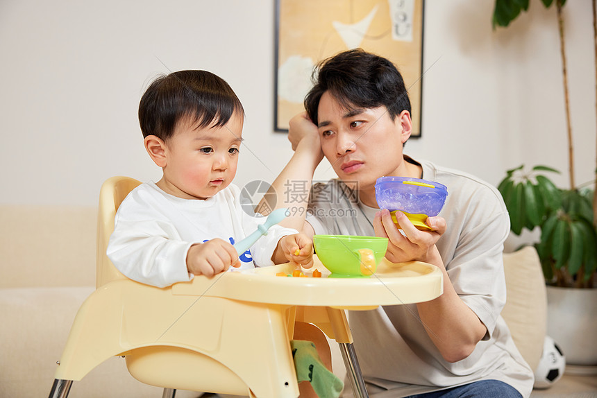 年轻奶爸给小宝宝喂食困难图片