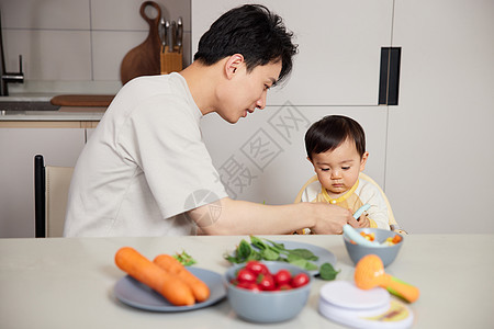 居家照顾宝宝饮食的年轻奶爸背景图片
