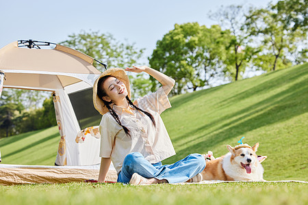 小狗和花公园里露营享受太阳的美女和爱宠背景
