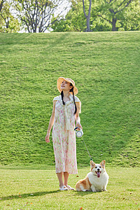 小狗在公园玩耍宠物狗狗和女主人在公园散步郊游背景