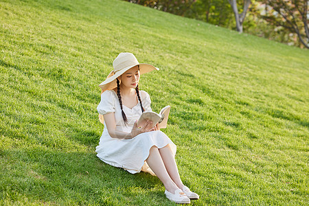 草坪上看书的文艺女性图片