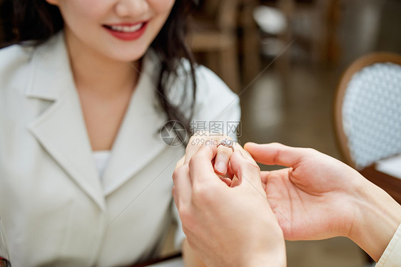 男性给女友戴上求婚戒指特写图片