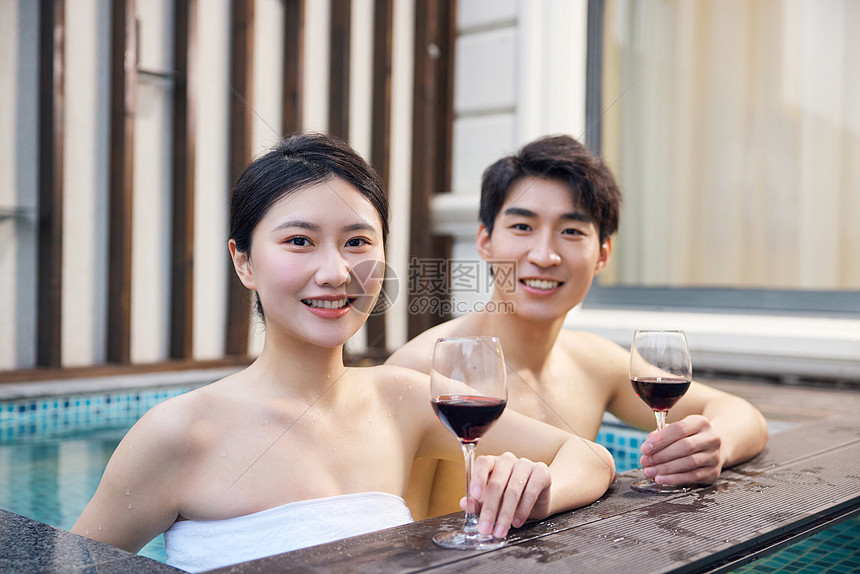年轻情侣泡温泉放松喝红酒形象图片