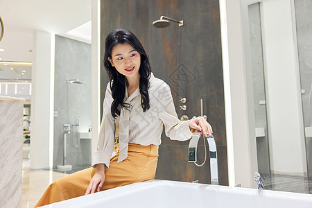 青年女性建材市场挑选浴缸背景图片
