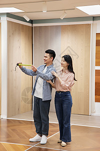 为新房挑选木地板的甜蜜夫妇形象图片