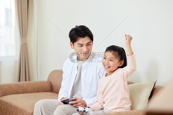 假期父女在家玩电子游戏获胜图片