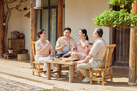 年轻夫妻节假日回家陪父母喝茶聊天高清图片