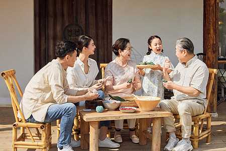 一家人看向小女儿端来的粽子背景图片