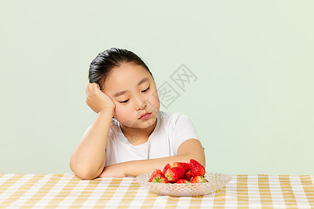 小女孩看着草莓低落图片